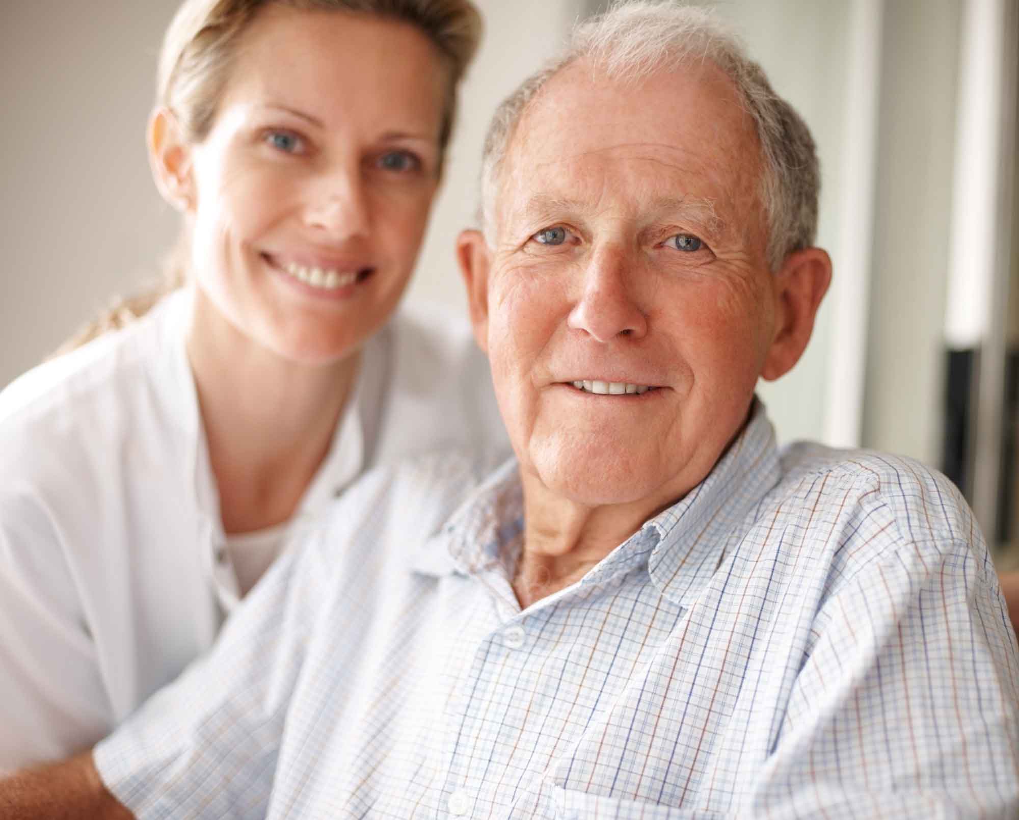 Elderly man on the wheelchair with a nurse